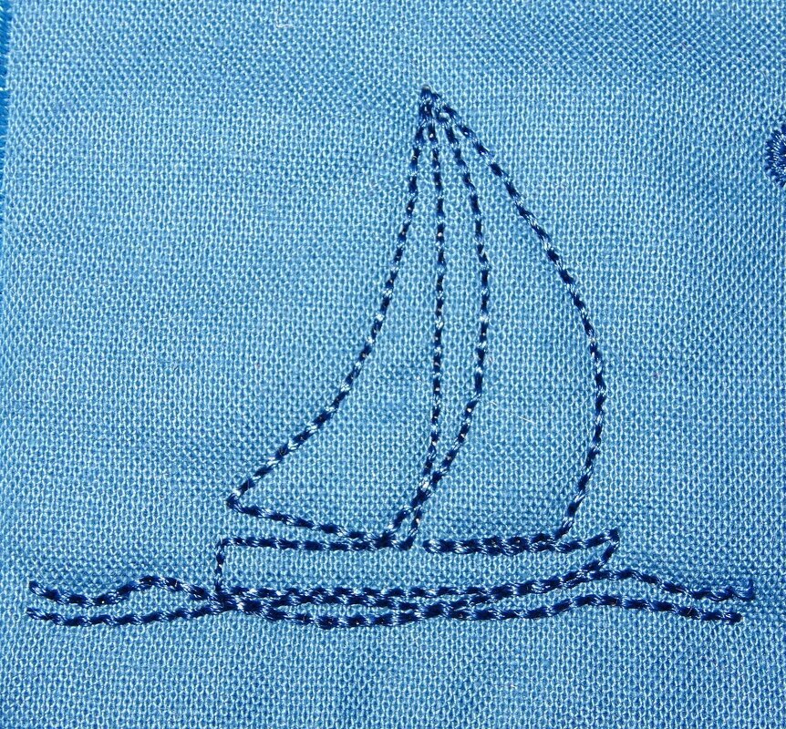 Stilisierte Stickerei eines Segelbootes mit zwei Segeln und Wellen in Dunkelblau auf hellblauem, strukturiertem Stoff