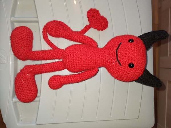 Gehäkeltes rotes Amigurumi mit langen Armen, Herzschwanz und schwarzen Hörnern