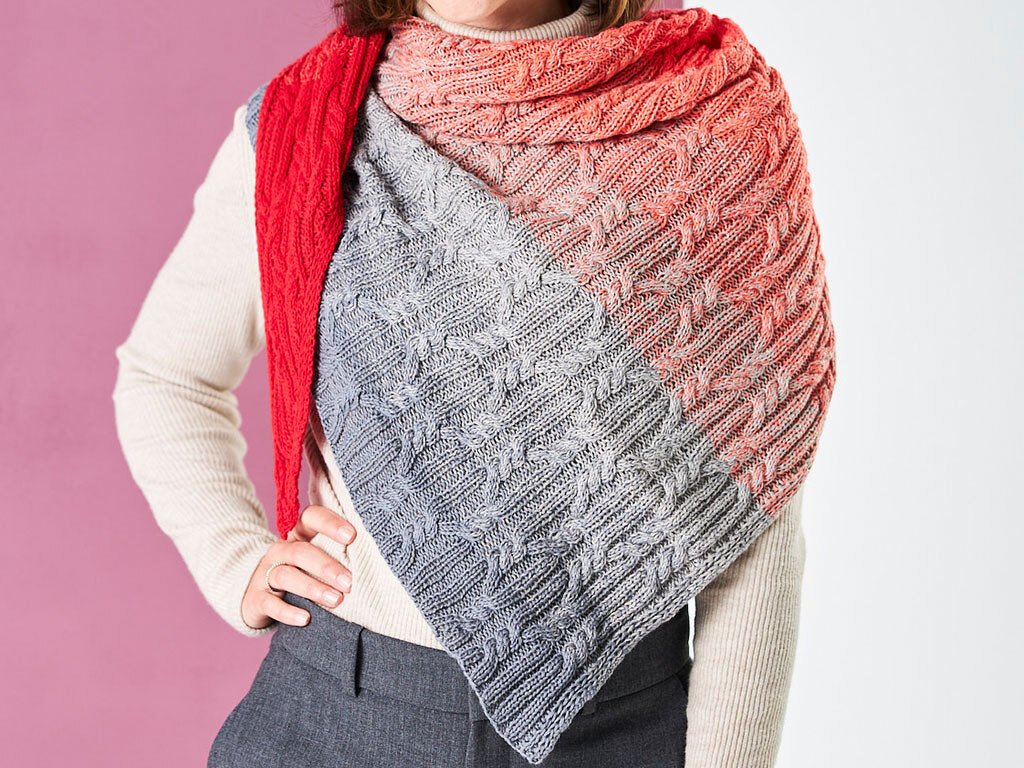 Gestricktes Dreieckstuch mit Farbverlauf von Rot über Orange zu Grau und Zopfmuster
