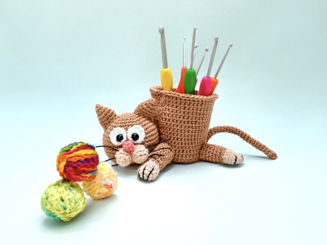 Gehäkelter Katzen-Stifthalter (Amigurumi) mit Häkelnadeln und bunten Wollknäueln
