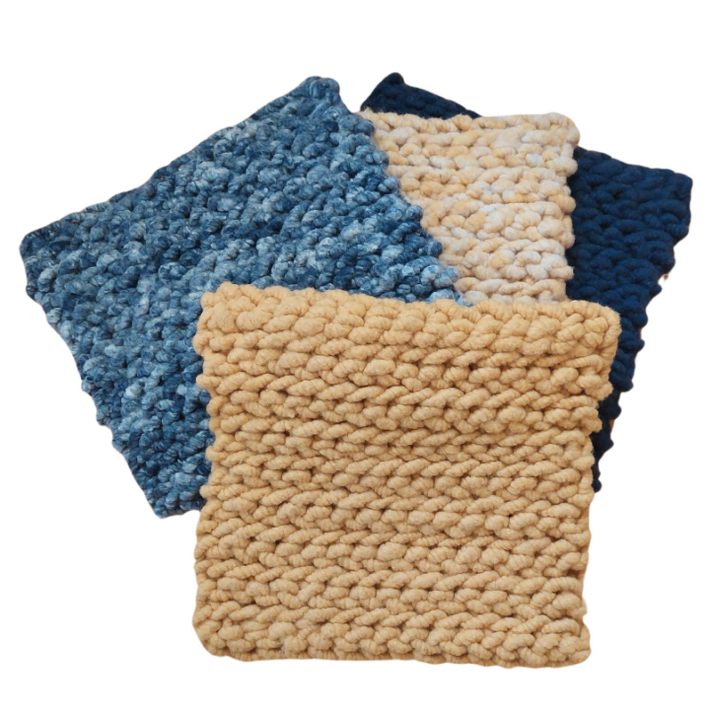 Vier gehäkelte Musterquadrate in Beige und Blautönen zum Vergleich von Farbe und Maschenbild