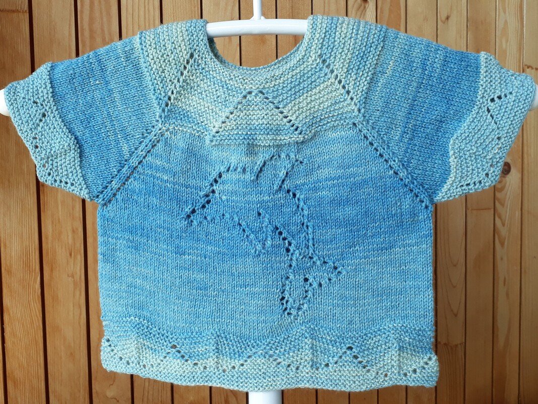 Blau-cremefarbener gestrickter Kinderpullover mit kurzen Ärmeln und Delfin-Lochmuster auf der Vorderseite.
