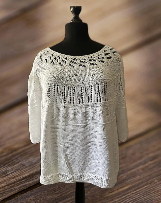 Weiße gestrickte Damen-Tunika mit Ajourmuster auf Schneiderpuppe