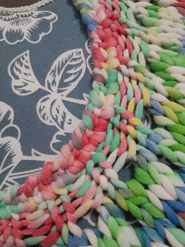 Nahaufnahme der Maschenstruktur und Rand eines dicken mehrfarbigen Garns