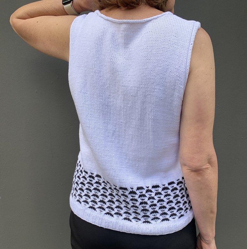 Rückenansicht eines weißen Stricktops mit kontrastierendem Muster am Bund