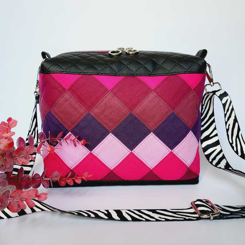 Gesteppte Umhängetasche in Pink und Lila mit Rautenmuster, schwarzer gesteppter Klappe und Zebra-Schultergurt.