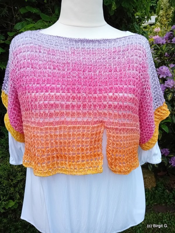 Gehäkelter Bolero mit Farbverlauf Lila–Pink–Orange auf Schaufensterpuppe