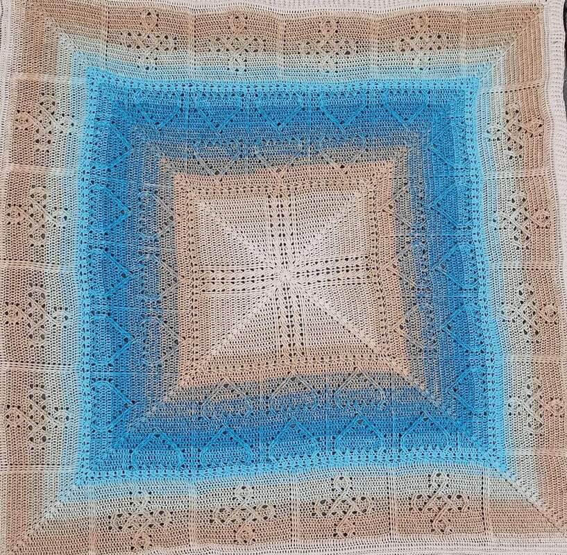 Quadratische gehäkelte Decke mit beige‑blauem Farbverlauf und sternförmigem Zentrum