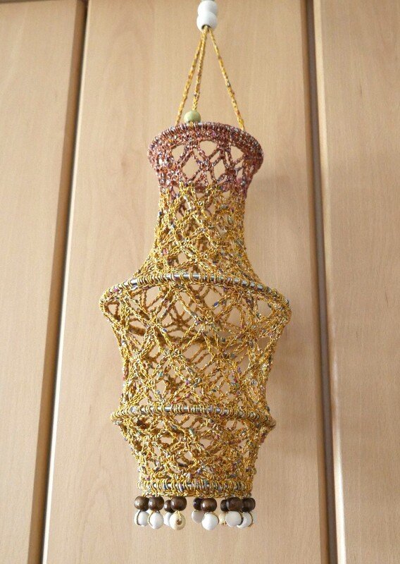 Gehäkelte goldfarbene Laterne mit Perlen am unteren Rand, hängend