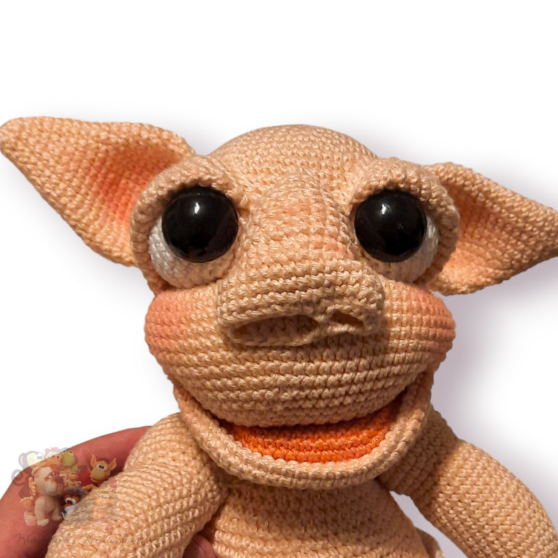 Gehäkelte Figur mit großen schwarzen Augen, spitzen Ohren und offenem Mund