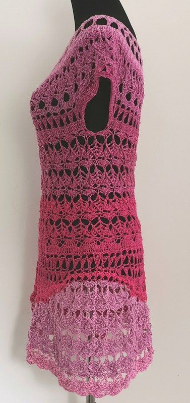 Gehäkelte Damen-Tunika in Pink mit Farbverlauf und dekorativem Lochmuster an Schneiderpuppe, Seitenansicht