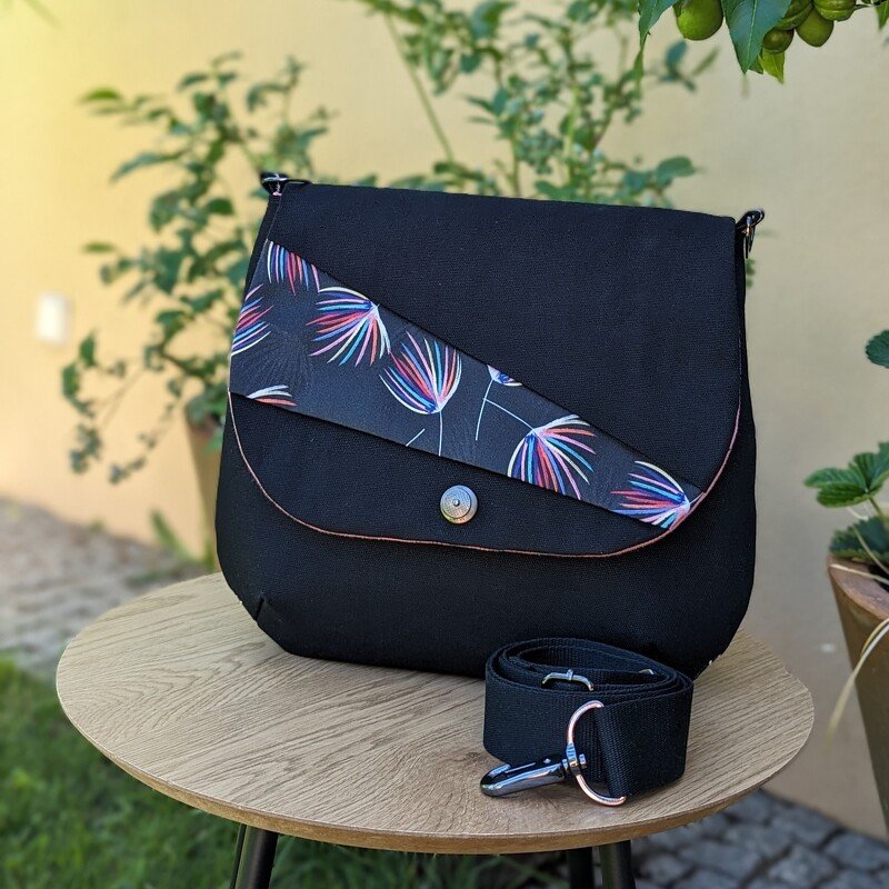 Schwarze Stoff-Umhängetasche mit diagonal gemusterter Klappe und abnehmbarem Gurt