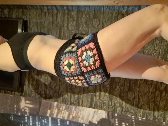 Woman wearing crocheted granny square shorts