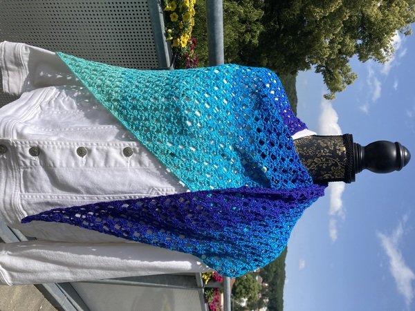 Gehäkeltes Dreieckstuch in Türkis, Blau und Violett an weißer Jacke