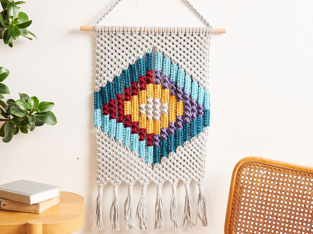 Nahaufnahme Makramee mit farbigem Rautenmuster und sichtbaren Knoten