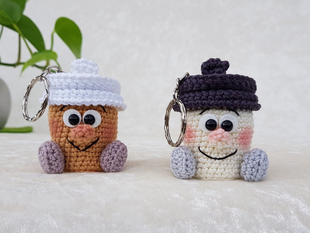 Zwei schnell gehäkelte Amigurumi-Schlüsselanhänger, ein brauner mit weißer Mütze und ein cremefarbener mit dunkler Mütze