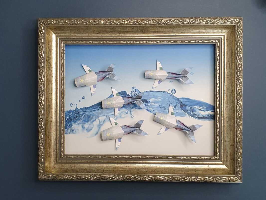 Antiker Bilderrahmen mit einem Schwarm aus gefalteten Geldschein-Fischen vor blauem Wellenmotiv