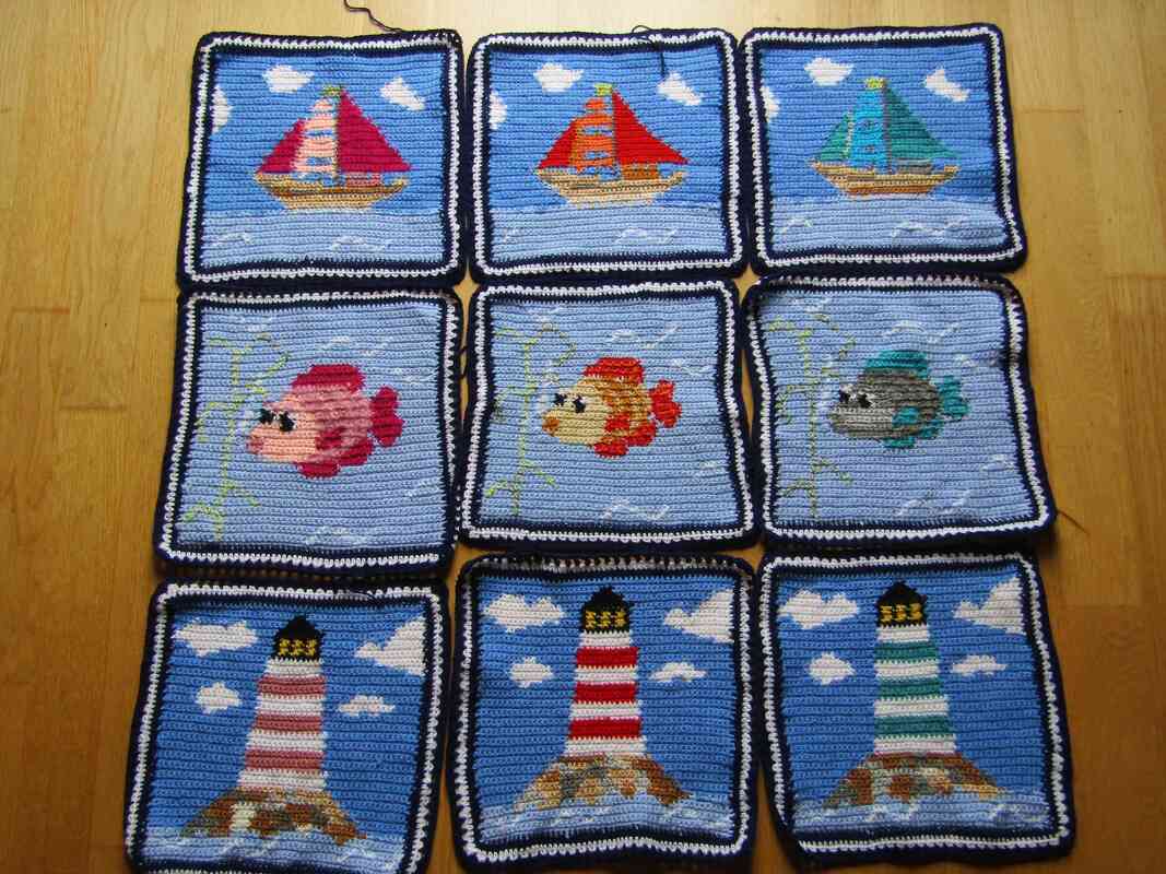 Neun gehäkelte Pixelquadrate mit Segelboot-, Fisch- und Leuchtturm‑Motiven auf blauem Grund