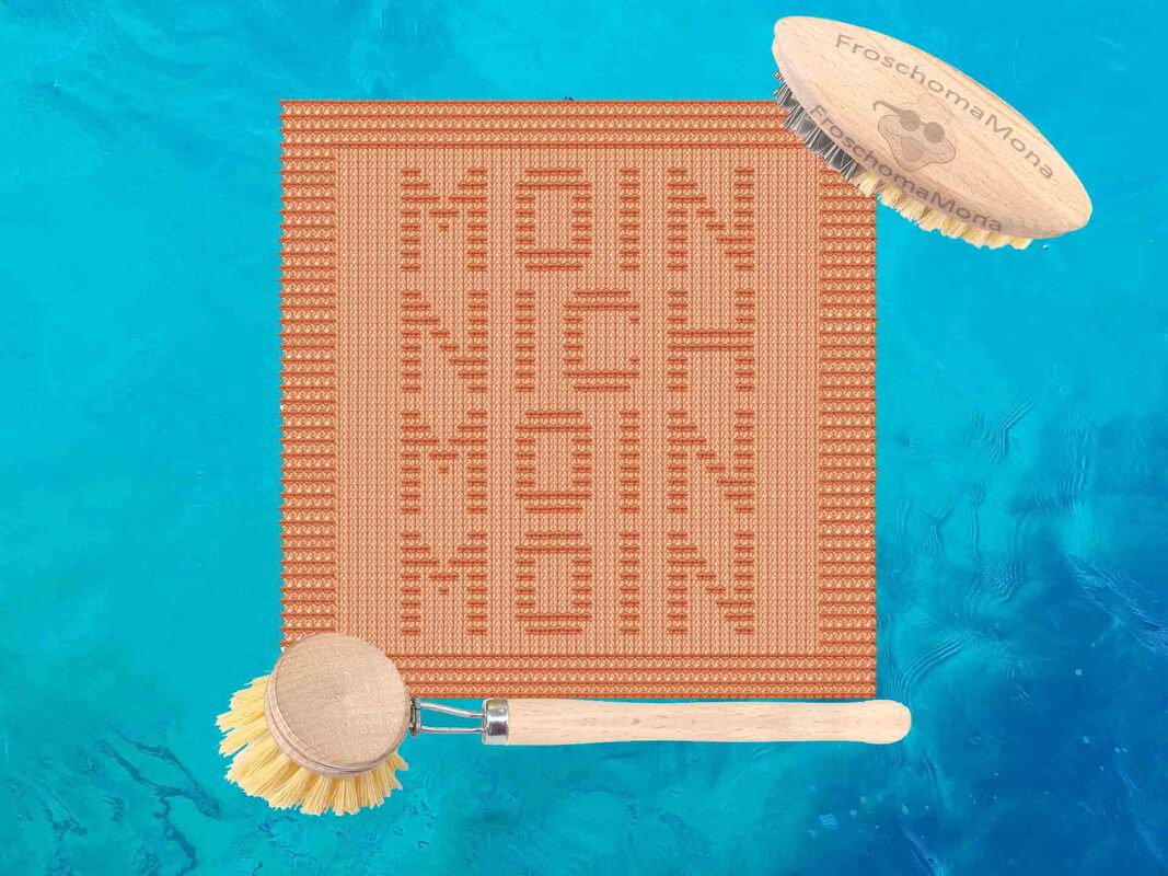 Terrakottafarbenes gestricktes Rechteck mit dem Wort „MOIN“ mehrfach vertikal eingestrickt vor blauem, welligem Hintergrund; zwei Holzbürsten mit hellen Borsten liegen daneben.