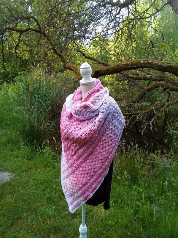 Gehäkeltes Dreieckstuch mit Farbverlauf und offenem Muster auf Schneiderpuppe im Garten