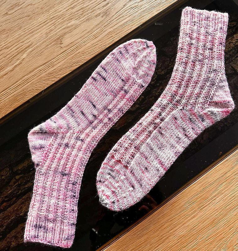 Zwei Stricksocken mit Rippenbündchen, abgerundeter Spitze und meliertem Garn