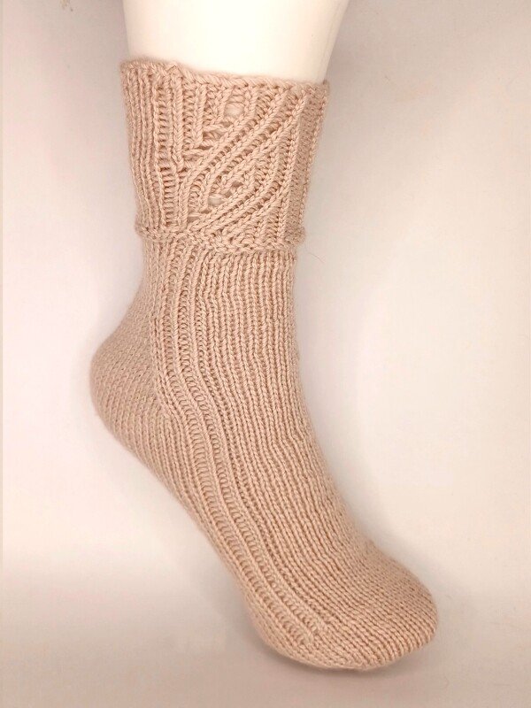 Beige gestrickte Socke mit Blatt-Ajourmuster am Schaft, auf Schaufensterpuppe