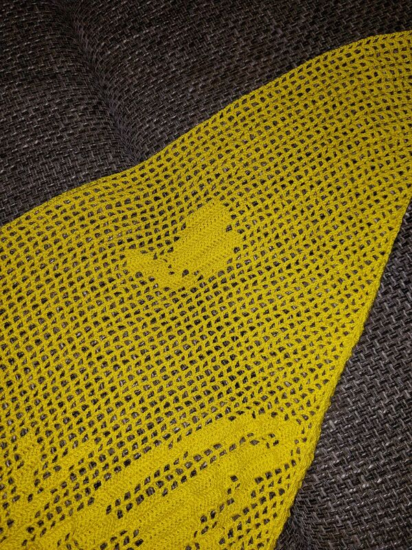 Nahaufnahme gelbes Häkel-Motivtuch mit deutlich sichtbaren Netzmaschen und Motivsegmenten