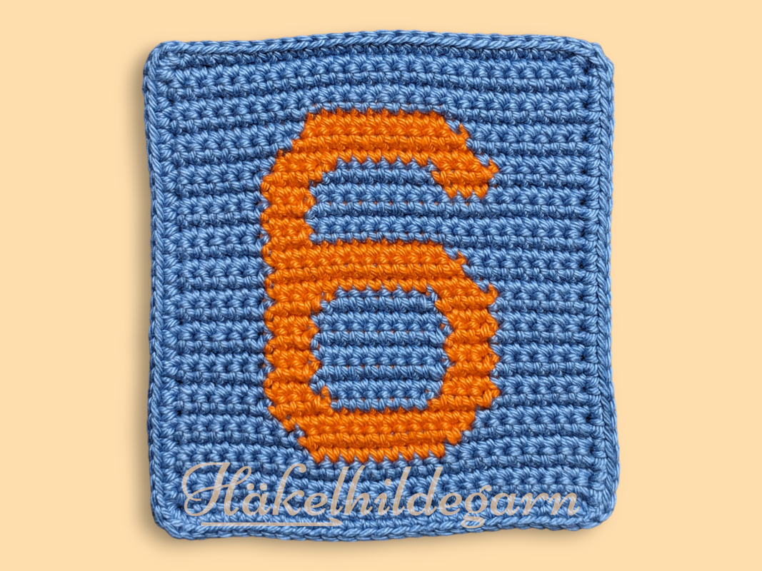 Gehäkeltes Pixelquadrat mit orangefarbener Zahl 6