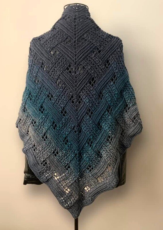 Back view of a crocheted triangle shawl in gradient charcoal to teal to pale gray with chevron lace panels