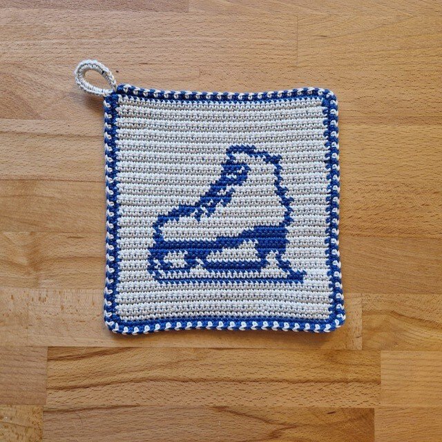 Quadratischer gehäkelter Topflappen cremeweiß mit blauem Rand, Schlittschuh-Motiv und Aufhängeschlaufe