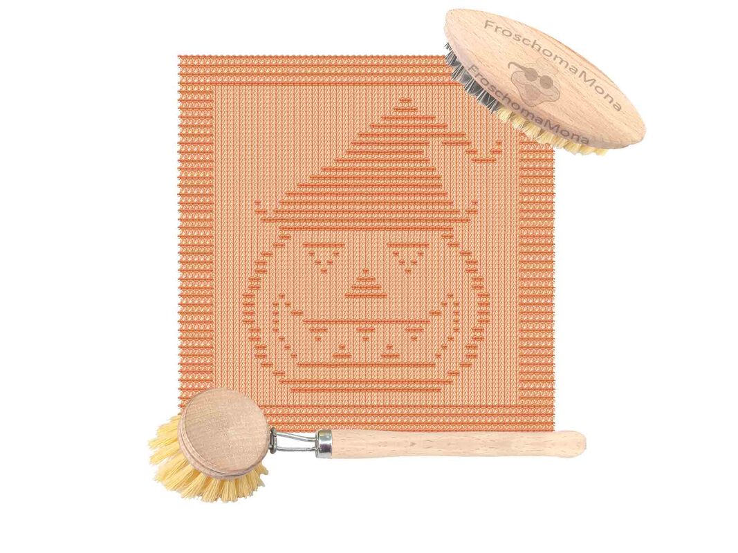 Orange gestricktes Küchentuch mit Kürbisgesicht und Hexenhut, zwei Holzspülbürsten