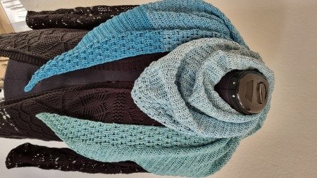 Gehäkeltes Dreieckstuch mit Türkis- und Hellblau-Farbverlauf drapiert auf einer Ankleidepuppe