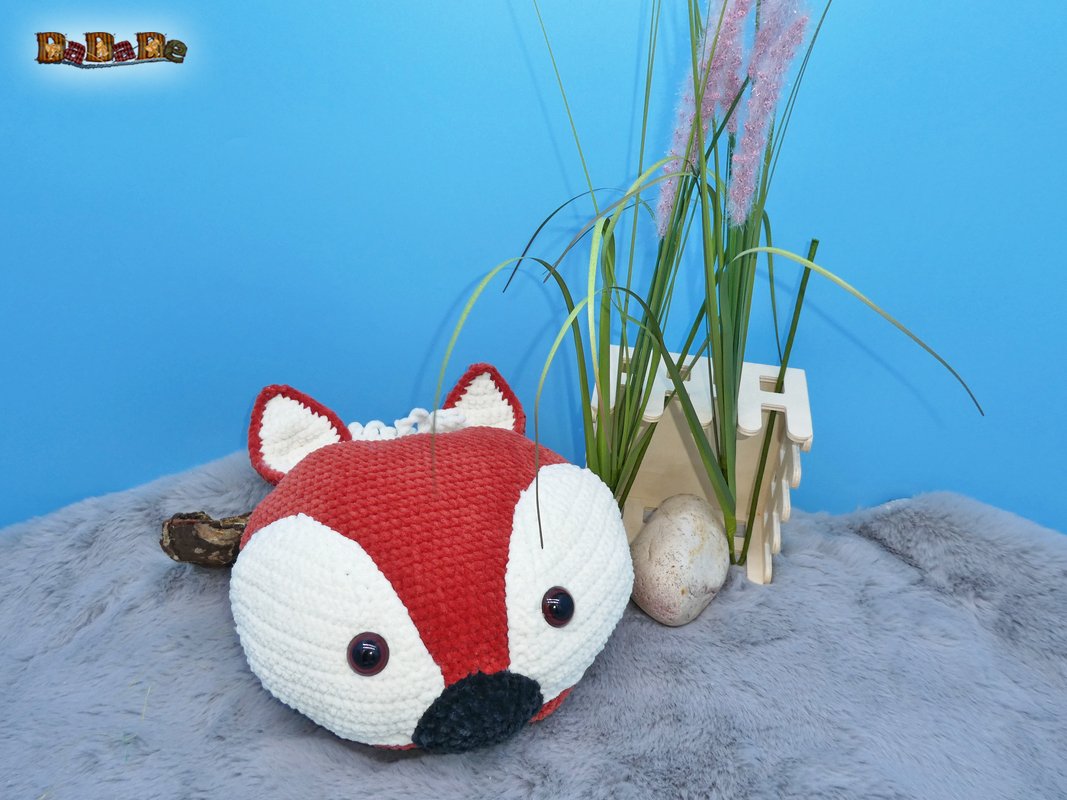 Gehäkelter Fuchskopf in rot und weiß auf grauem Kunstfell