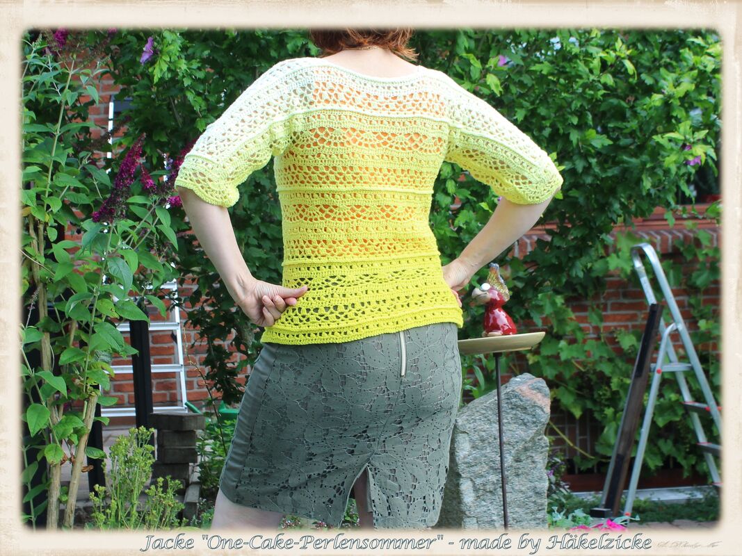 Person von hinten trägt eine gehäkelte Jacke in Gelb-Grün mit Ombre-Verlauf und Lochmuster.