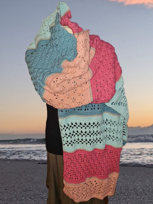 Großer mehrfarbiger Häkel-Schal mit Loch- und Wellenmustern, getragen am Strand