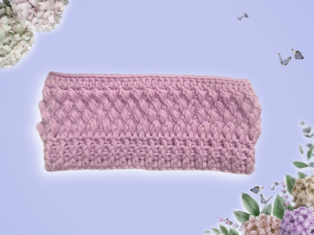 Fliederfarbenes gehäkeltes Stirnband mit reliefartiger Struktur auf hellem Hintergrund