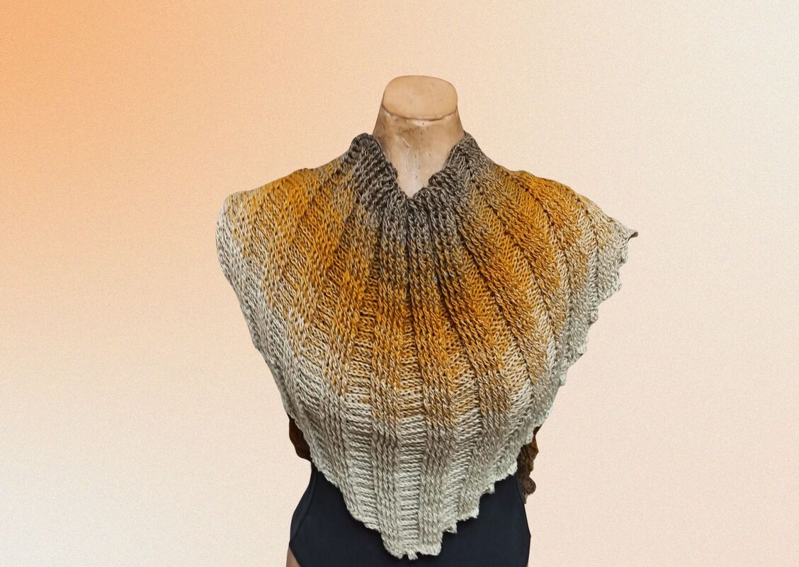 Gehäkeltes Dreieckstuch in Grau, Senfgelb und Beige mit Rippenstruktur auf einer Schaufensterpuppe