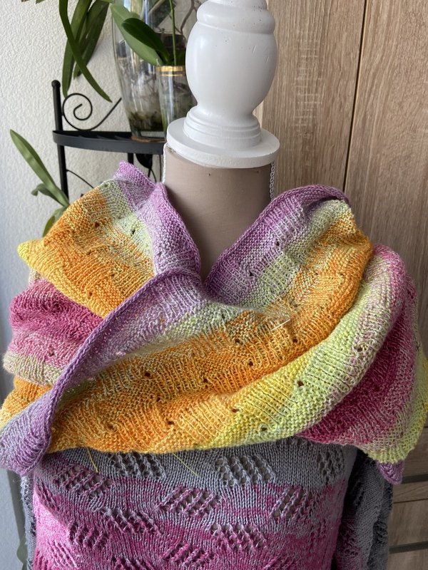 Mehrfarbiger gestrickter Loop mit Ajourmuster auf Büste drapiert