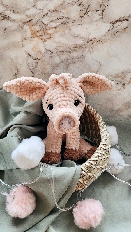 Gehäkeltes Amigurumi‑Schwein im Körbchen, zartrosa mit dunklen Hufen