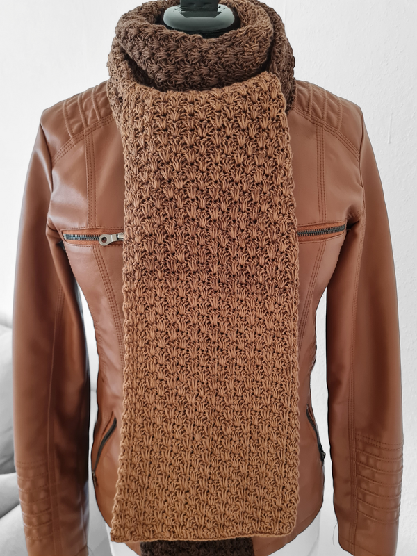 Brauner gehäkelter Schal mit strukturiertem Maschenbild über brauner Jacke an Schaufensterpuppe