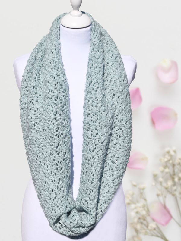 Hellmintfarbener gestrickter Loop-Schal mit Ajourmuster auf weißer Schneiderpuppe