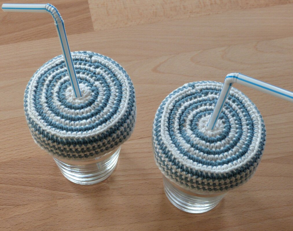 Zwei flache, schnell gehäkelte Glasabdeckel in Blau und Weiß mit Strohhalmen