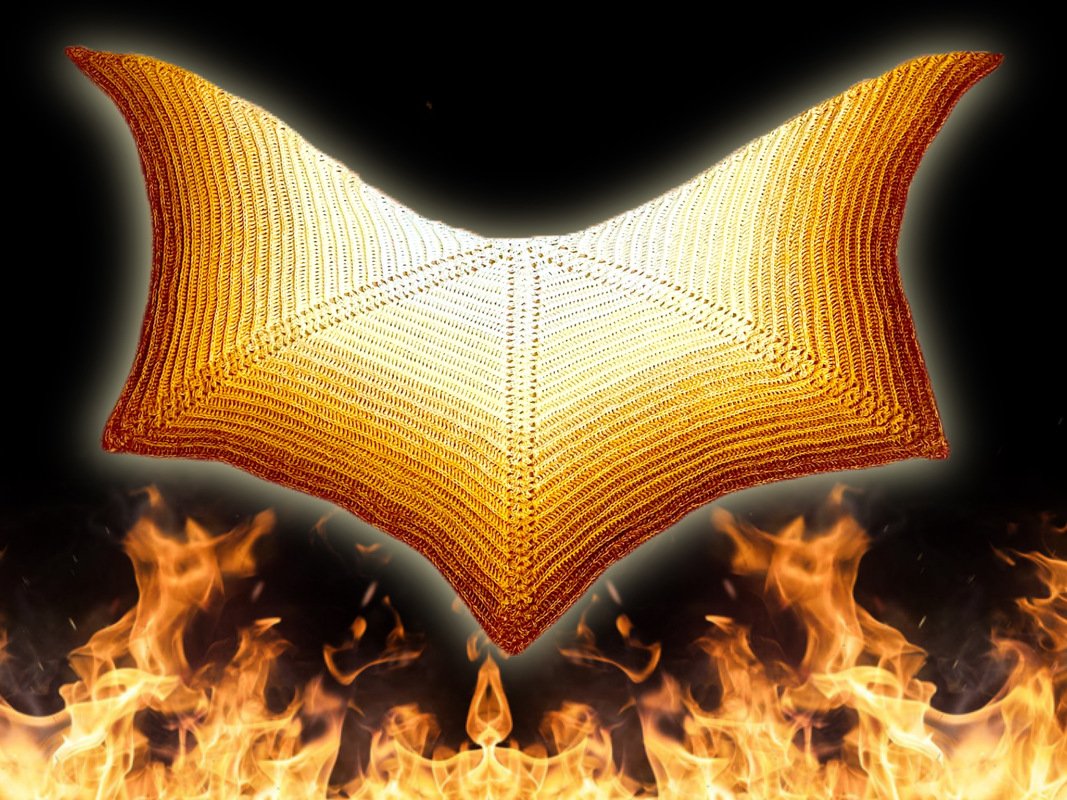 Gehäkeltes Dreieckstuch in Gold-, Orange- und Weißtönen mit sanftem Farbverlauf, vor Flammen-Hintergrund.