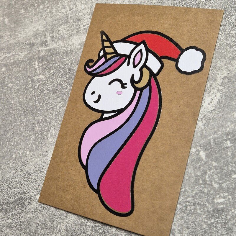 Einhornplott mit klaren schwarzen Konturen, rosa-violetter Mähne und roter Weihnachtsmütze auf braunem Hintergrund