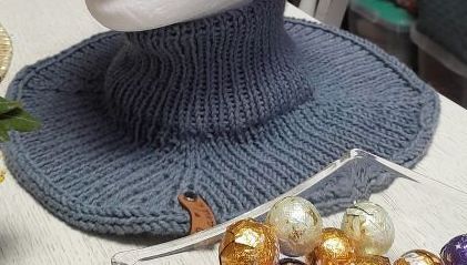 Blau-grauer Strickhut mit breiter Krempe, hohem geripptem Oberteil und dickem Garn