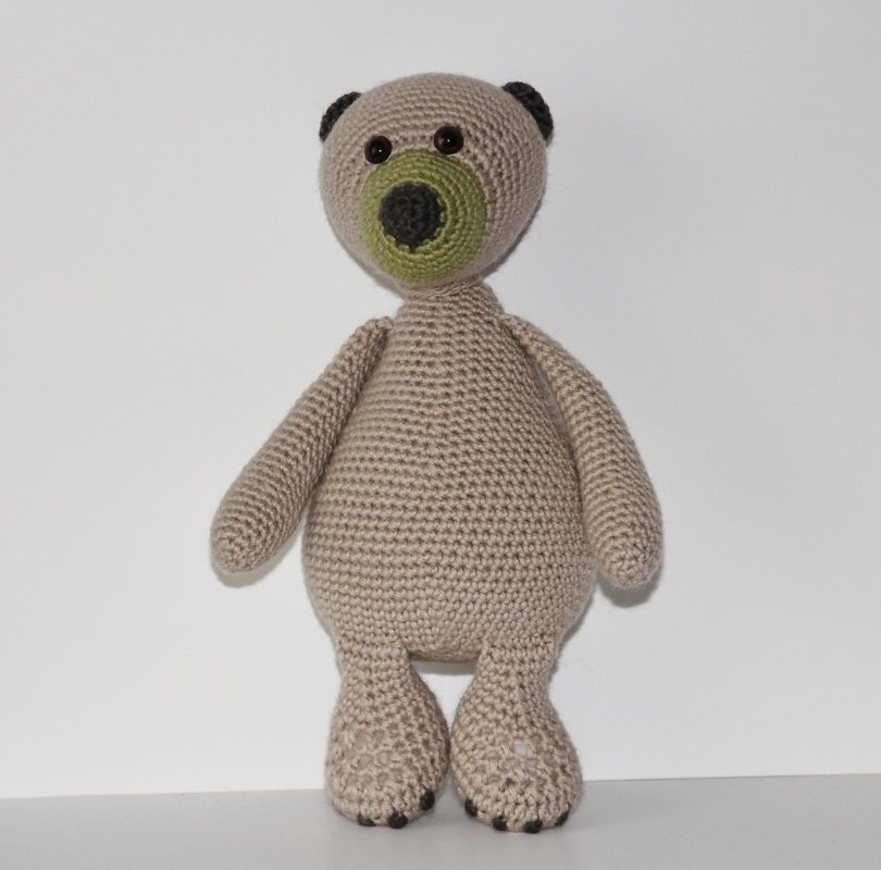Gehäkelter beiger Amigurumi-Teddybär mit grüner Schnauze und schwarzen Knopfaugen