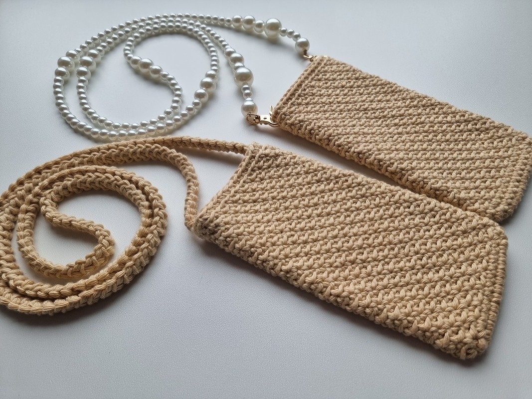 Zwei beigefarbene gehäkelte Taschen, eine mit Häkelriemen, eine mit Perlenriemen