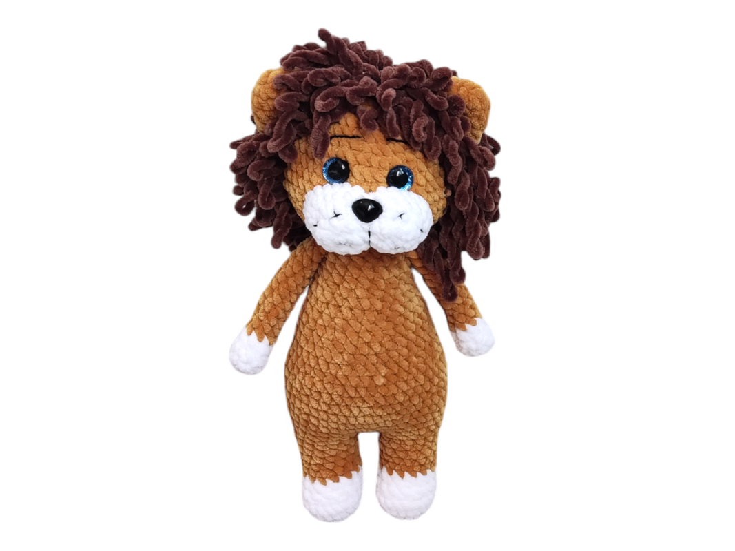 Gehäkelter Amigurumi-Löwe mit braunem Körper, dunkler Mähne, hellblauen Augen und weißen Pfoten.