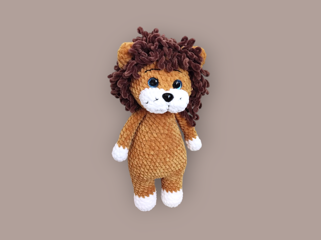 Gehäkelter Amigurumi-Löwe mit braunem Körper, dunkler Lockenmähne und weißer Schnauze.