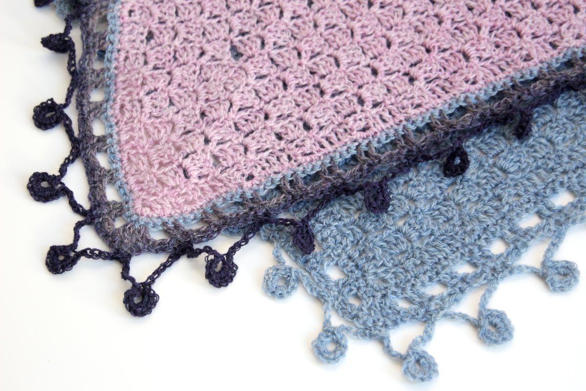 Detailaufnahme einer Dreieckstuchkante mit Gruppenmaschen und kleinen gehäkelten Bommeln